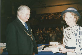 Photograph of Muriel Gibson being presented by Lord Mansfield with the keys of a car given to her...