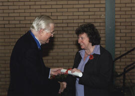 Photograph of Elma McCausland receiving a scroll from Lord Mansfield at the AGM, 2004